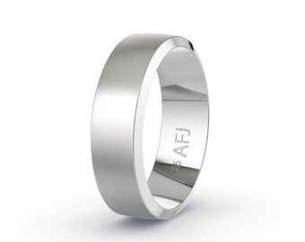 May include: A silver-colored ring with a brushed metal finish. The ring has a flat top and beveled edges. The inside of the ring is engraved with "AFJ" and "985".