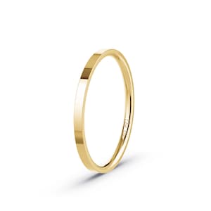 May include: A thin, polished gold ring with a flat band. The ring is a bright, shiny yellow color and appears to be made of solid gold. The ring is shown against a white background.