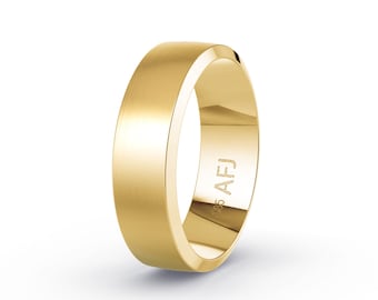 May include: A gold wedding band with a brushed finish. The ring has a flat profile and a polished interior. The inscription "AFJ" and "585" are visible on the inside of the ring. The ring is a classic design.