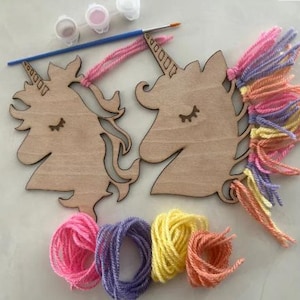 Può includere: Un kit fai-da-te per unicorno con due sagome di teste di unicorno in legno, vasetti di vernice, un pennello e filato colorato. Gli unicorni hanno gli occhi chiusi e corna dettagliate. Sono inclusi gomitoli di filato rosa, viola, giallo e arancione per la criniera.