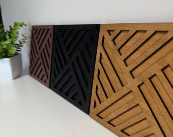 Può includere: Tre pannelli di arte murale in legno con disegni geometrici. I pannelli sono in tonalità di marrone, nero e legno naturale. Ogni pannello ha una forma quadrata con un motivo ripetuto di linee diagonali, creando un aspetto moderno e strutturato.