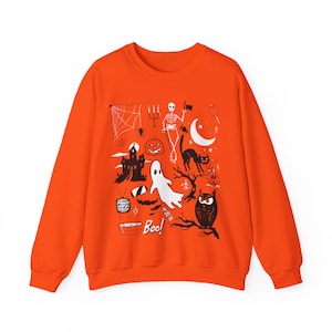 May include: Orange sweatshirt with a Halloween-themed design featuring a ghost, skeleton, owl, bats, spider web, and the text "Boo!"