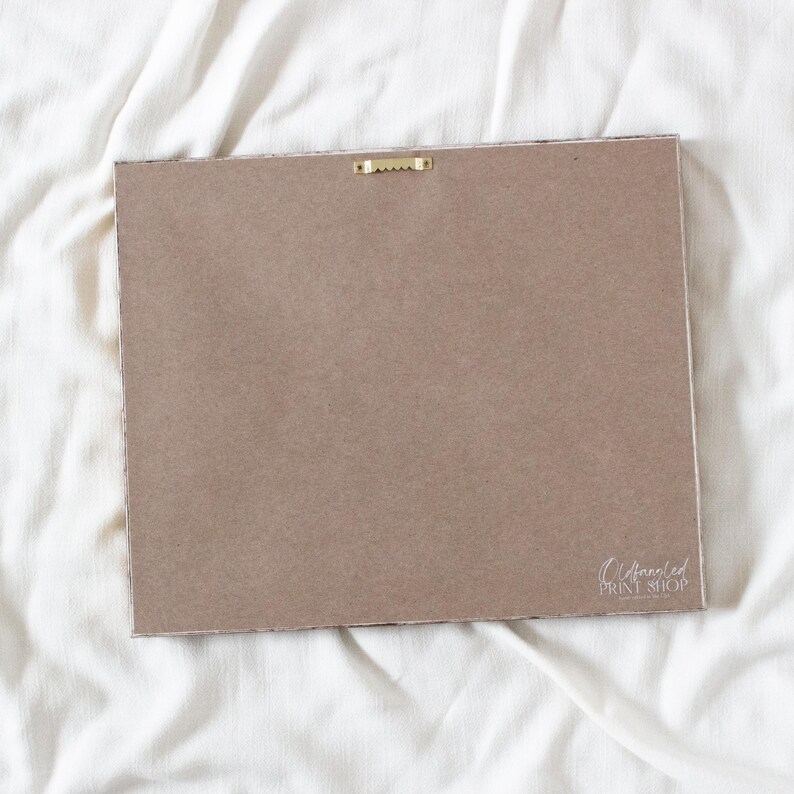 a blank, brown-colored piece of paper or card lying on a white, crumpled fabric surface.