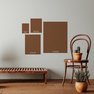 a room with a wooden bench, a wooden chair, and a potted plant. There are four square photographs of varying sizes displayed on the wall, each labeled with the corresponding size in inches.