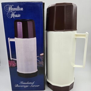May include: A white and brown insulated beverage server with a handle, next to its blue box. The box reads "Hamilton House" and "Insulated Beverage Server". The server has a white body, a brown top and base, and a white handle.