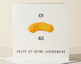 May include: A white greeting card with the words "ICH AUS" and "HEUTE IST DEINE JUGENDWEIHE" in black. A single, golden-yellow cheese puff is centered on the card. The card is placed on top of a white envelope.