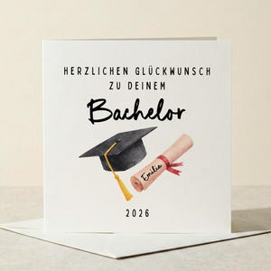 Könnte beinhalten: Eine weiße Abschlusskarte mit dem Text "HERZLICHEN GLÜCKWUNSCH ZU DEINEM Bachelor" in Schwarz. Die Karte zeigt eine Aquarellillustration einer Abschlusskappe, eines Diploms und das Jahr 2026.