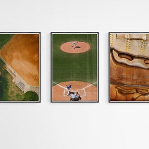 K&ouml;nnte beinhalten: Drei gerahmte Drucke eines Baseballfeldes, eines laufenden Baseballspiels und einer Nahaufnahme eines braunen Lederbaseballhandschuhs mit dem Text "Edgemont" darauf.