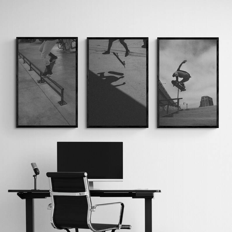 Puede incluir: Tres fotograf&iacute;as enmarcadas en negro de patinadores haciendo trucos. Las fotos est&aacute;n colgadas en una pared blanca sobre un escritorio con un monitor de computadora negro, un micr&oacute;fono y una silla de oficina negra.