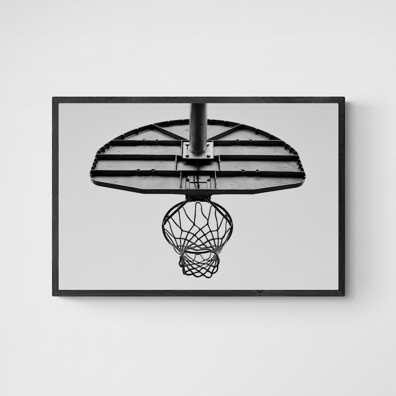May include: Black and white photo of a basketball hoop with a net. The hoop is made of metal and has a backboard with a series of horizontal lines. The net is made of a woven material and hangs from the hoop.
