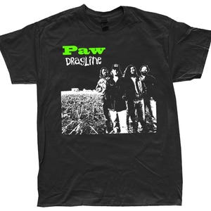 以下が含まれることがあります： バンドのグラフィックが特徴の黒いTシャツ。デザインには、緑と白で「Paw Dragline」というバンド名と、野原に立っているバンドメンバーの白黒画像が含まれています。このシャツは、クラシックなクルーネックです。