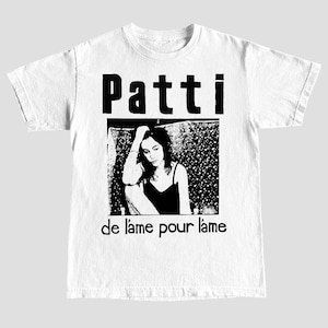 Puede incluir: Camiseta blanca con una imagen en blanco y negro de una mujer y el texto "Patti de l'ame pour l'ame".