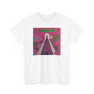 Puede incluir: Camiseta blanca con un diseño gráfico colorido y el texto "Socrates drank the conium". El diseño muestra una escalera que conduce a un arco, con nubes y árboles rosas. La camiseta tiene un cuello redondo clásico.