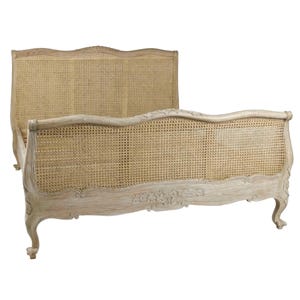 May include: A light-coloured wooden bed frame with a woven cane headboard and footboard. The frame has ornate carvings and curved legs, creating a vintage aesthetic. The bed frame is designed for a standard mattress.