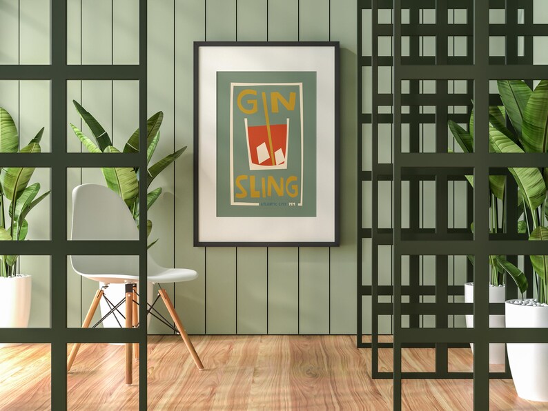 Puede incluir: Una l&aacute;mina de arte enmarcada con una ilustraci&oacute;n gr&aacute;fica de un c&oacute;ctel rojo en un vaso con cubitos de hielo y una pajita, con el texto GIN SLING en letras amarillas sobre un fondo verde suave dentro de un marco negro fino.