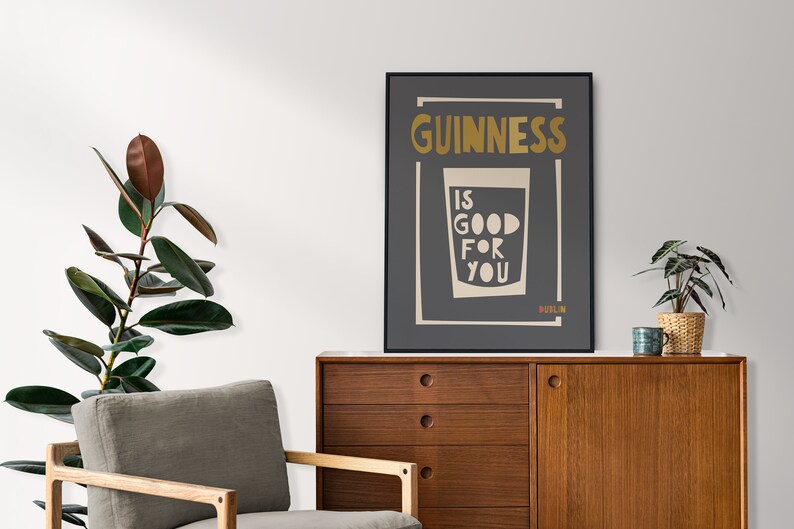 Op de afbeelding: Een zwart-witte poster met de tekst "GUINNESS IS GOOD FOR YOU" in een gouden lettertype. De poster toont ook een glas Guinness met het woord "DUBLIN" onderaan.