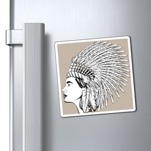 May include: A square magnet featuring a black and white illustration of a person in profile wearing a feathered headdress. The image is set against a tan background.