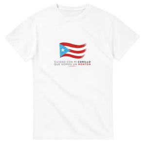 Könnte beinhalten: Weißes T-Shirt mit einem Design der puerto-ricanischen Flagge in Rot, Blau und Weiß. Der Text "CUIDAO CON MI CORILLO QUE SOMOS UN MONTON" ist ebenfalls in Rot und Blau enthalten.