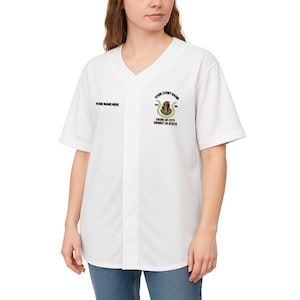Könnte beinhalten: Weißes Baseball-Trikot mit V-Ausschnitt und kurzen Ärmeln. Das Trikot trägt den Text "YOUR NAME HERE" auf der linken Brust und ein Teamlogo mit dem Text "YOUR COURT NAME" und "OASIS OF CITY DESERT OF STATE" auf der rechten Brust.