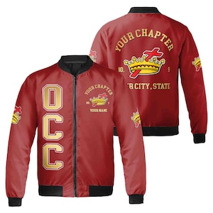 May include: Red bomber jacket with a gold embroidered crown and cross design. The jacket has the text "Your Chapter" and "Your City, State" on the back. The front of the jacket has the letters "OCC" in gold.