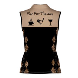 May include: A sleeveless golf shirt with a tan collar and a black and brown leopard print design. The back of the shirt has the text "Plan For The Day" with a coffee cup, golf club, and wine glass graphic.