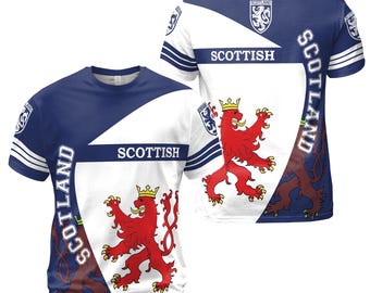 Puede incluir: Una camiseta azul y blanca con un león rojo y las palabras "SCOTLAND" y "SCOTTISH" impresas en ella.