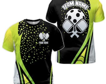 Könnte beinhalten: Schwarz-gelbes sublimiertes T-Shirt mit einem weißen Pickleball-Schläger und Ball-Motiv. Auf der Rückseite des Shirts steht "Team Name".