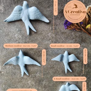 Op de afbeelding: Een verzameling lichtblauwe keramische zwaluwbeeldjes in verschillende maten, vari&euml;rend van 10,5 cm tot 20 cm lang. De afbeelding bevat de tekst "A Creativa Ceramics" en website-informatie.