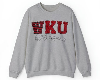 May include: A gray sweatshirt with the letters WKU in red, black, and white patterned fabric. The letters are outlined in red and the words "hilltoppers" are written in black script below the letters.