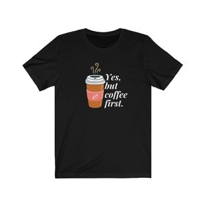 May include: Black t-shirt with a white coffee cup graphic and the text "Yes, but coffee first."