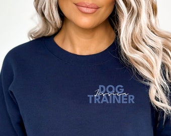 Puede incluir: Una sudadera corta azul marino con el texto "DOG TRAINER" en letras azules en la parte delantera.