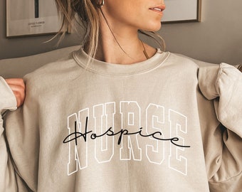 May include: A beige sweatshirt with the text "NURSE Hospice" printed in black and white.