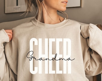 May include: A beige sweatshirt with the text "CHEER Grandma CHEER" printed in white and black.