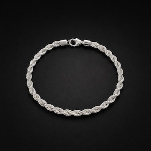 May include: A silver-toned rope chain bracelet featuring a twisted metal design with a polished finish. The bracelet is secured with a metal lobster claw clasp mechanism that connects the two ends of the circular chain link structure.