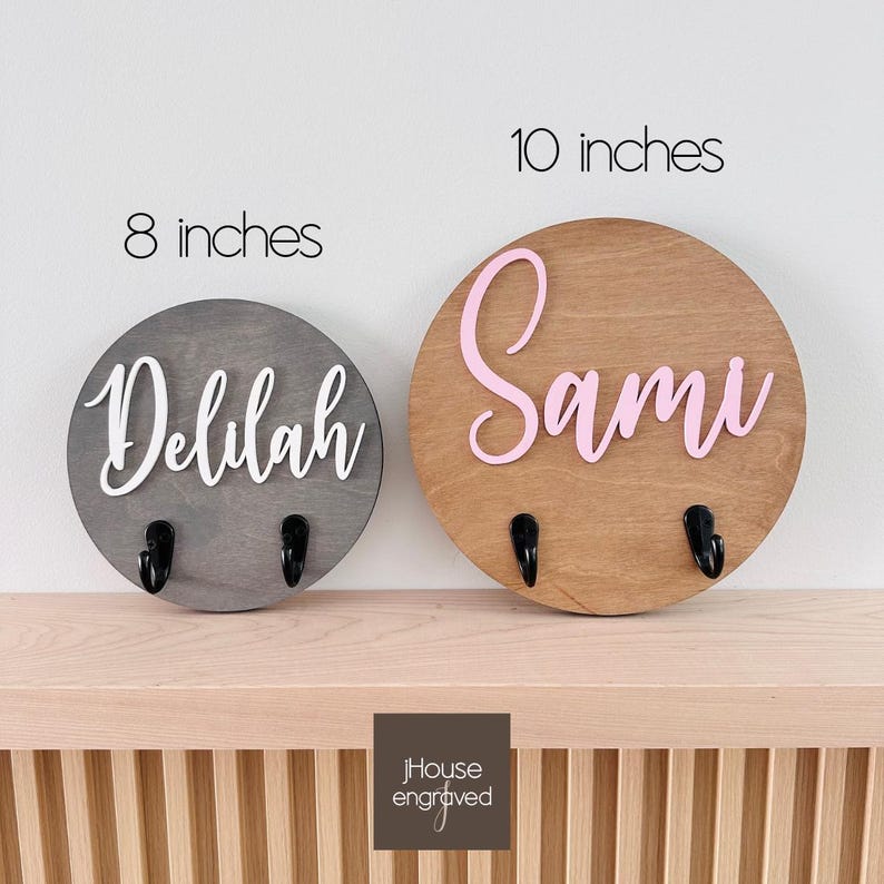 Puede incluir: Dos placas de pared circulares de madera con ganchos. La placa gris de 8 pulgadas tiene el nombre Delilah en letra cursiva blanca. La placa de madera natural de 10 pulgadas tiene el nombre Sami en letra cursiva rosa. Dos ganchos negros.