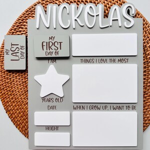 Puede incluir: Un letrero de madera gris y blanco con el nombre "Nickolas" en la parte superior. El letrero tiene espacios para completar informaci&oacute;n sobre la persona, como su edad, altura y lo que quiere ser cuando crezca.