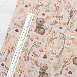 Pu&ograve; includere: Un motivo senza cuciture con animali del bosco che indossano sciarpe e cappelli. Lo sfondo &egrave; beige chiaro con foglie marroni, verdi e arancioni. Gli animali includono cervi, gufi, conigli e orsi.