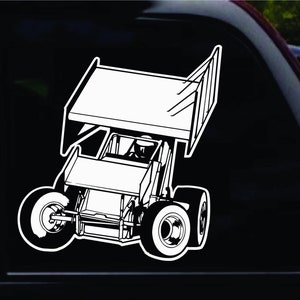 May include: A black and white line drawing of a sprint car, a type of open-wheeled race car, with a driver in the cockpit. The car has a large wing on the back and is in a racing position.