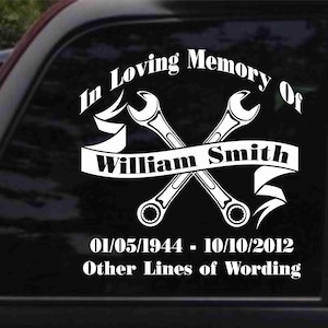K&ouml;nnte beinhalten: In liebevoller Erinnerung an William Smith, ein wei&szlig;er Vinyl-Aufkleber mit zwei gekreuzten Schraubenschl&uuml;sseln und einem Banner. Die Daten 01/05/1944 - 10/10/2012 und der Text "Other Lines of Wording" sind ebenfalls enthalten.