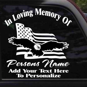 May include: In Loving Memory Of decal with a black and white American flag and a bald eagle flying over it. The text "Persons Name" is below the flag and the text "Add Your Text Here To Personalize" is below that.