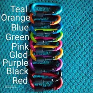 May include: A stack of ten colorful metal carabiners in teal, orange, blue, green, pink, gold, purple, black, and red.