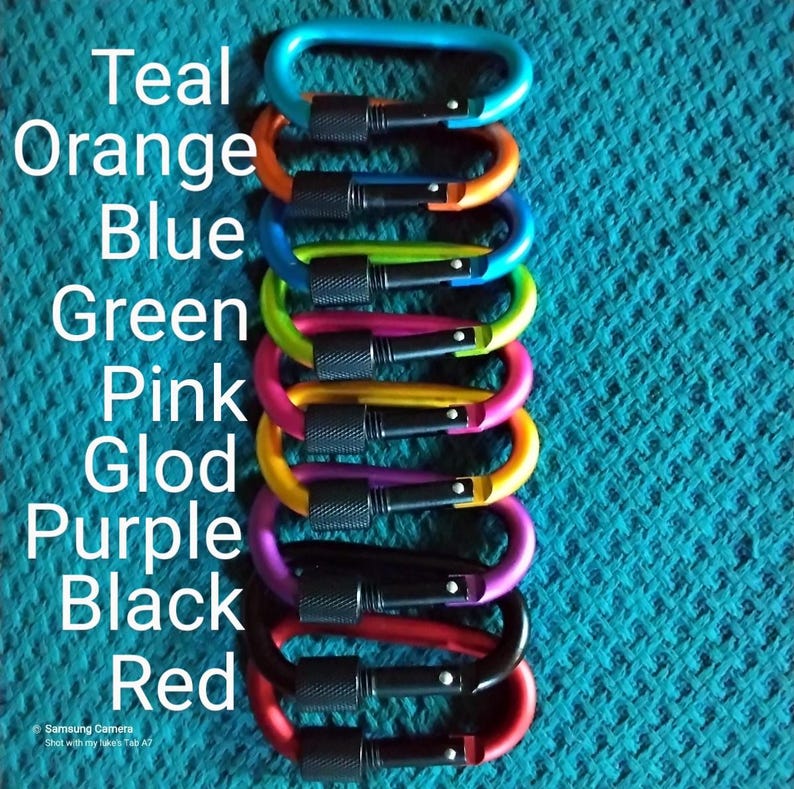 May include: A stack of ten colorful metal carabiners in teal, orange, blue, green, pink, gold, purple, black, and red.