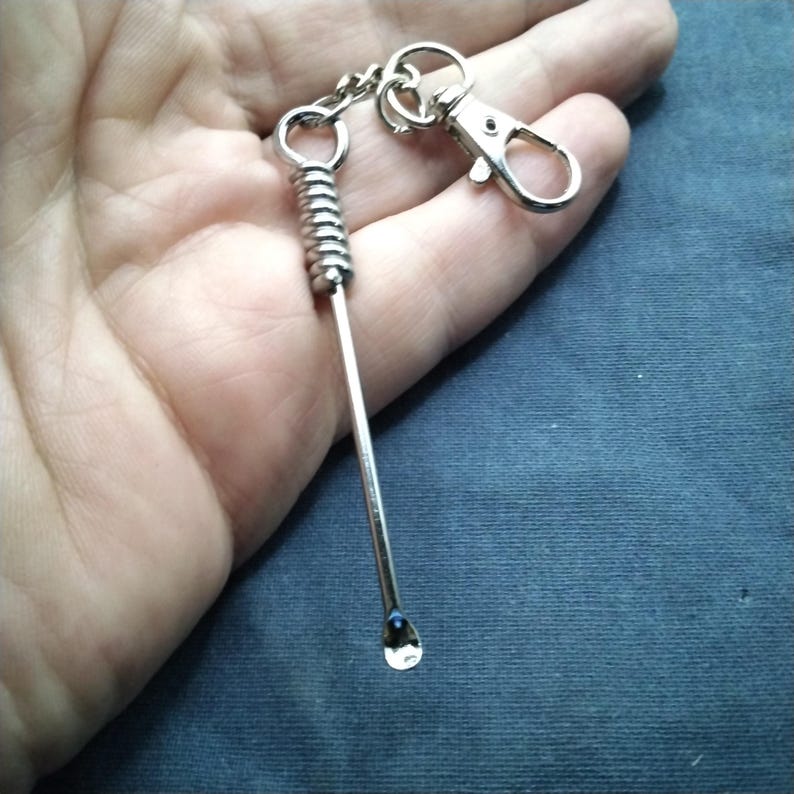 Puede incluir: Un accesorio de llavero de color plateado con un peque&ntilde;o extremo en forma de cuchara. El llavero incluye un resorte en espiral y un cierre para sujetar. El art&iacute;culo est&aacute; dise&ntilde;ado para uso personal y est&aacute; hecho de metal brillante.