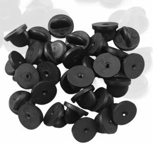 May include: A pile of black plastic pin back closures for badges, buttons, or other crafts.