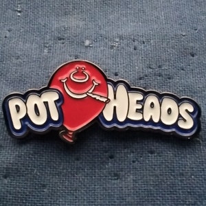 May include: A red balloon with a smiling face and a cigarette in its mouth, with the text "POT HEADS" in white letters with blue outlines.