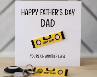 Puede incluir: Una tarjeta blanca con el texto "Happy Father's Day Dad" y un nivel amarillo con el texto "Best Dad" en él. La tarjeta también tiene el texto "You're on another level".
