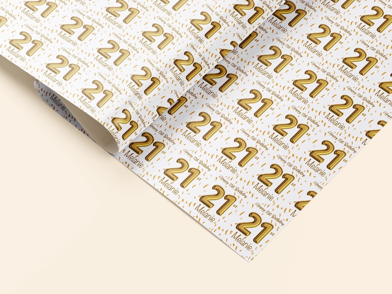 Op de afbeelding: Wit cadeaupapier met een herhalend patroon van gouden folie 21's en confetti. De tekst "Happy 21st Birthday Melanie" wordt in het hele patroon herhaald.