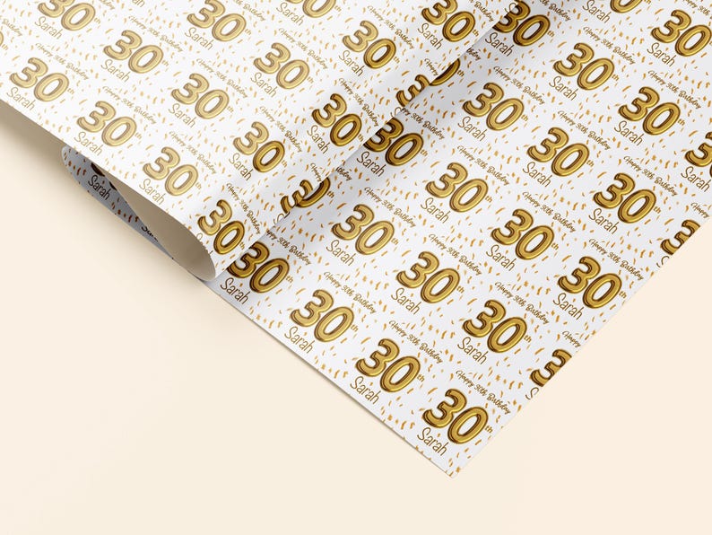 May include: White wrapping paper with a repeating pattern of gold 30th birthday balloons and confetti. The text "Happy 30th Birthday" and the name "Sarah" are repeated throughout the pattern.