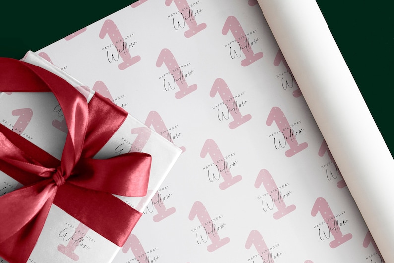 K&ouml;nnte beinhalten: Rosa-wei&szlig;es Geschenkpapier mit einem sich wiederholenden Muster aus rosa Einsen mit wei&szlig;en Punkten und dem Text "Happy Birthday Willow".