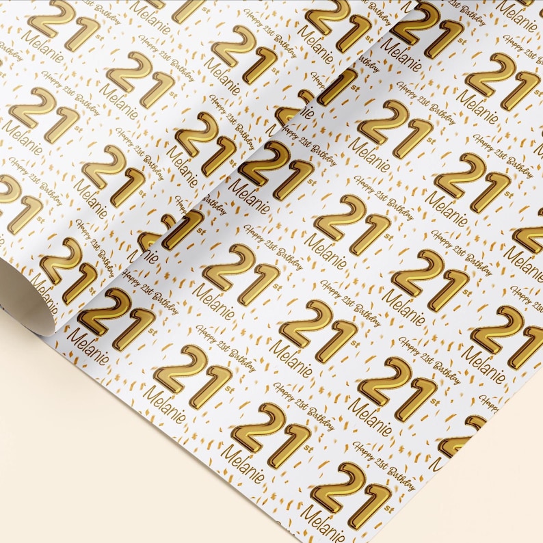 Op de afbeelding: Wit inpakpapier met een herhalend patroon van gouden 21e verjaardagsciffers en confetti. De tekst "Happy 21st Birthday" en de naam "Melanie" worden in het hele patroon herhaald.
